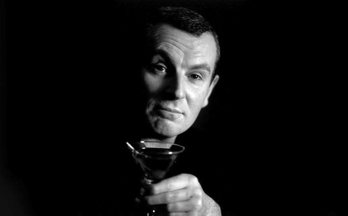 Zwart-witportret van bartender Dick Bradsell met een cocktailglas